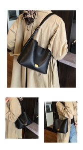 Gros plan du sac seau noir en cuir grainé avec logo doré et design minimaliste épuré