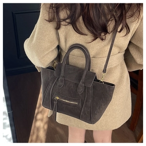 Detailansicht der dunkelbraunen Retro-Muscheltasche mit verstellbarem Riemen am Model
