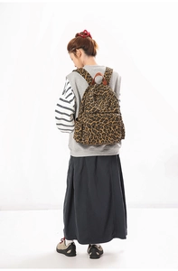 Leopard-Leinwandrucksack mit Ledergriff am Modell zur Darstellung von Größe und Stil