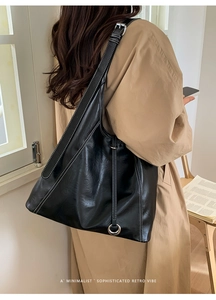 Détail du sac cabas noir avec surpiqûres blanches contrastées et boucle métallique