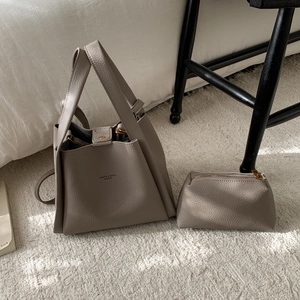 Detail of clay gray lychee grain leather tote bag set with inner zipper pouch