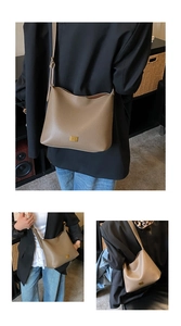 Détail de la texture en cuir marron litchi et du logo en métal doré sur le sac fourre-tout