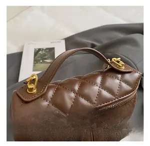 Detail showing brown quilted texture and faux suede stitching on the stylish boston handbag