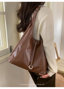 Close-up of retro brown tote bag with contrast stitching and silver ring detail