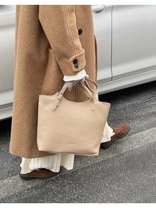 Litchi texture beige tote bag styled with a brown coat for an elegant commute
