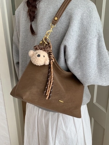 Retro brown oversized shoulder bag with plush bear charm and metallic hardware