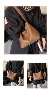 Sac seau en cuir grainé marron avec logo doré, porté à l'épaule et en bandoulière