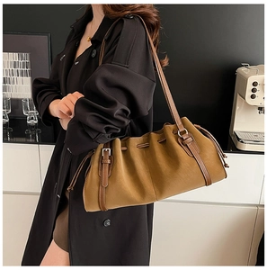 Detail of vintage caramel brown tote bag featuring drawstring pleats and silver metal buckle