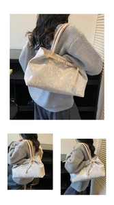 Detail of large beige tote bag with abstract letter prints and sturdy shoulder straps