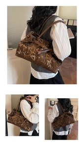 Close-up of a large dark brown tote bag featuring abstract letter graffiti and shoulder straps