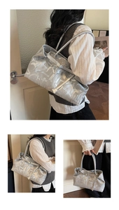 Detail of silver metallic tote bag with abstract white art print and long shoulder strap