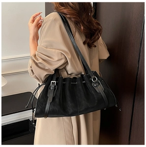 Detail of black drawstring pleated shoulder bag showing side buckle and leather texture