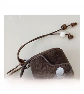 Detail view of mini vintage suede earphone bag with brown lychee leather and silver buckle