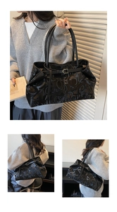 Detail of black large capacity tote bag with embossed letter texture and leather strap