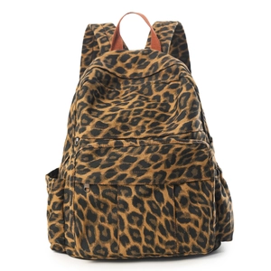 Detail eines Canvas-Rucksacks mit Leopardenmuster, Fronttasche und orangefarbenem Griff