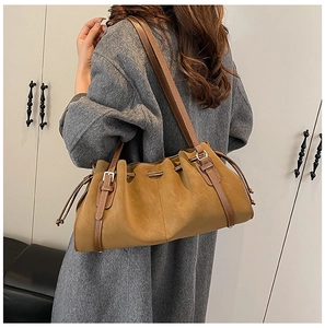 Detail of ginger leather tote bag featuring drawstring pleats and adjustable buckle strap