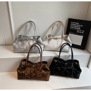 Detail view of four large tote bags in silver, cream, coffee, and black with letter patterns