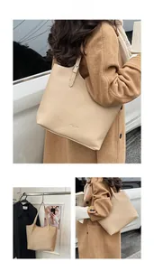 Detail of beige tote bag with litchi grain texture and adjustable shoulder strap