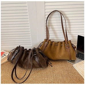 Detail of vintage drawstring tote bags in coffee and camel suede with pleated design