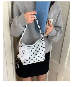 Détail du sac porté épaule à pois blancs avec charmant pendentif de chiot en peluche