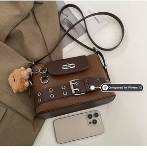 Sac baguette marron texturé à côté d'un iPhone 12 pour montrer sa taille compacte