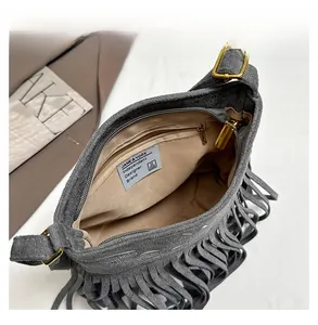 Close-up of deep gray matte suede fringe bag showing brown lining and inner zip pocket