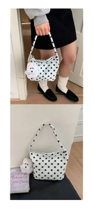 Détail du sac à bandoulière à pois avec un joli charme de chien en peluche sur tissu