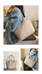 Detail view of beige tote bag featuring premium lychee texture leather and slim straps