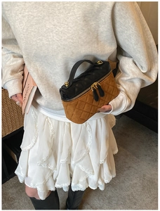 Detail of quilted leather handbag with dual zipper closure and contrasting textures
