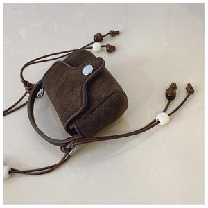 Detailed view of a vintage brown leather mini bag with beads and silver snap button