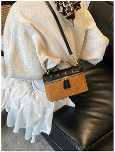 Detail of a quilted patchwork shoulder bag with leather finish and gold zipper detail