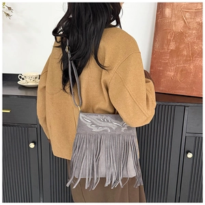 Macro view of gray fringe crossbody bag with sequin embroidery and long tassel details