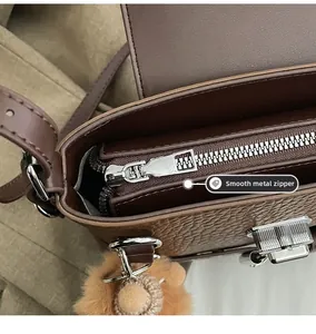 Détail du zip métallique fluide et du cuir marron texturé sur un sac baguette