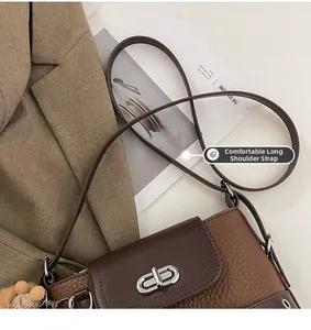 Détail du sac bandoulière bicolore avec fermoir rotatif argenté et pompon en peluche
