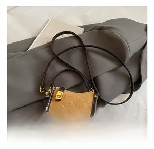 Detailed view of quilted handbag with brown leather trim and golden twist lock closure