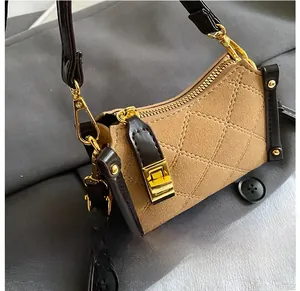 Detail of beige quilted suede handbag with gold lock and brown leather trim