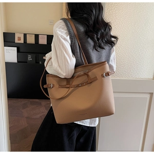 Détail du cabas caramel en cuir grainé avec boucles réglables et lettrage doré chic