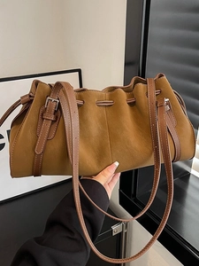 Caramel brown ruched leather drawstring bucket bag with adjustable shoulder strap detail