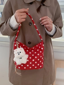 Sac hobo rouge à pois blancs avec charmant pendentif chien en peluche sur la bandoulière