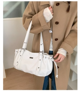 White PU leather tote bag with drawstring and silver rivets shown on a model