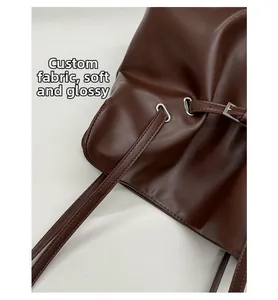 Detail of soft wrinkled faux leather texture and silver buckle on dark brown bag