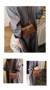 Detail view of retro brown quilted box bag with gold metal hardware and adjustable strap