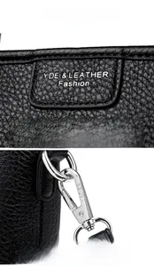 Close-up of black litchi pattern leather with YDE logo and silver metal buckle detail