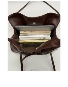 Spacious interior of dark brown leather tote bag holding a tablet and books
