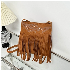 Detail of bohemian brown suede crossbody bag with long fringes and leaf embroidery