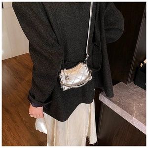 Detailed view of a metallic silver quilted crossbody bag on person for scale and style