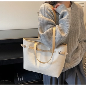 Détail du sac cabas en cuir grainé avec lanières contrastées et détails de rivets