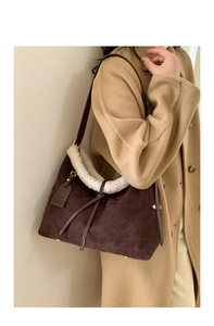 Detail of dark brown suede tote bag with faux shearling trim and embossed patterns