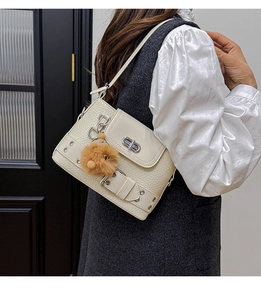 Détail du sac bandoulière en cuir crème avec fermoir en argent et pendentif en peluche