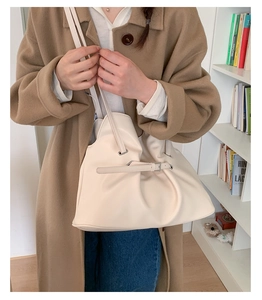 Close-up of beige pleated shoulder bag with soft matte leather and decorative buckle